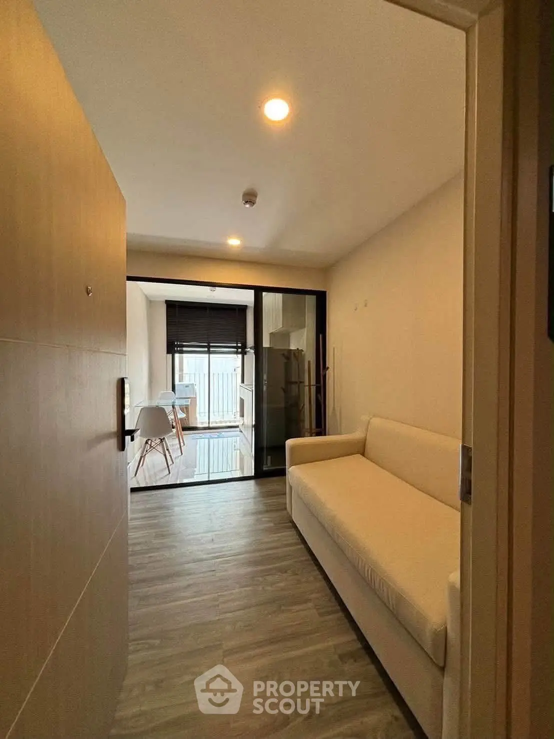 Modern apartment entrance with cozy sofa and dining area view