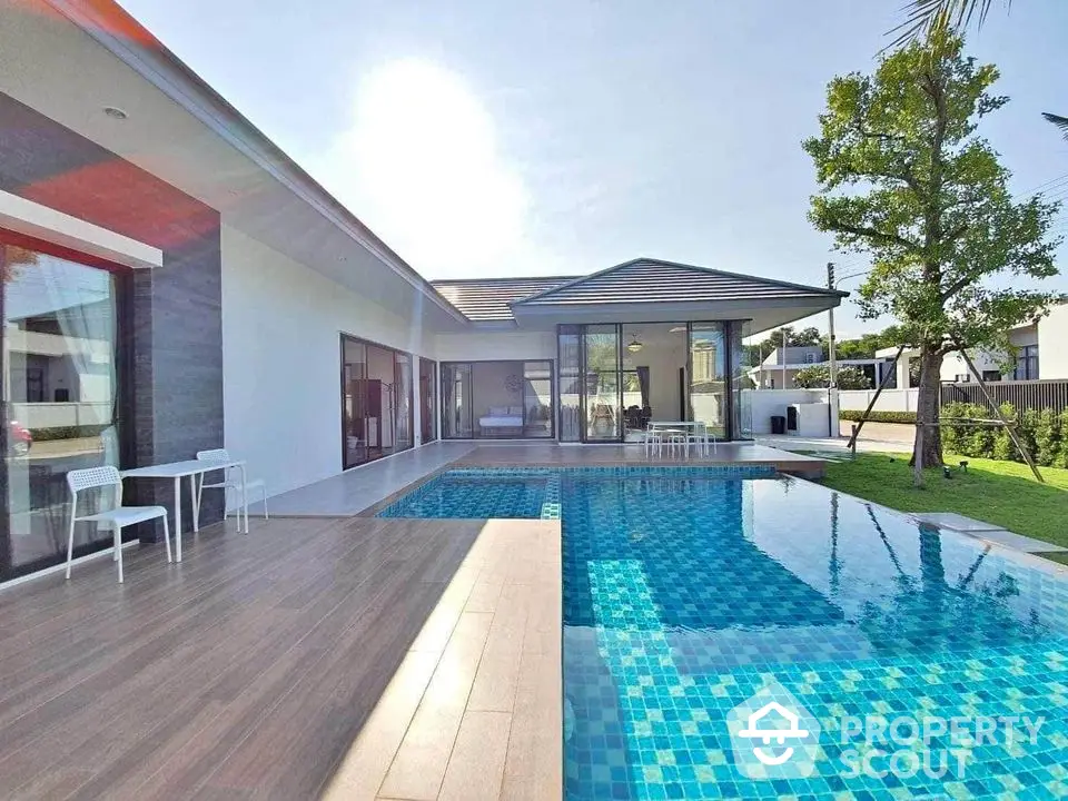 Luxurious modern villa with private pool and spacious patio in serene setting.