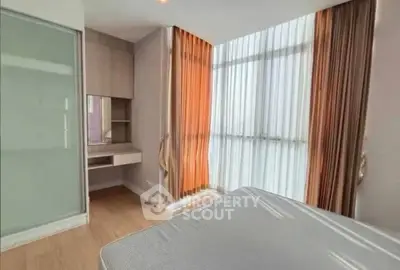 Bright bedroom with large windows and modern furnishings in a stylish apartment.