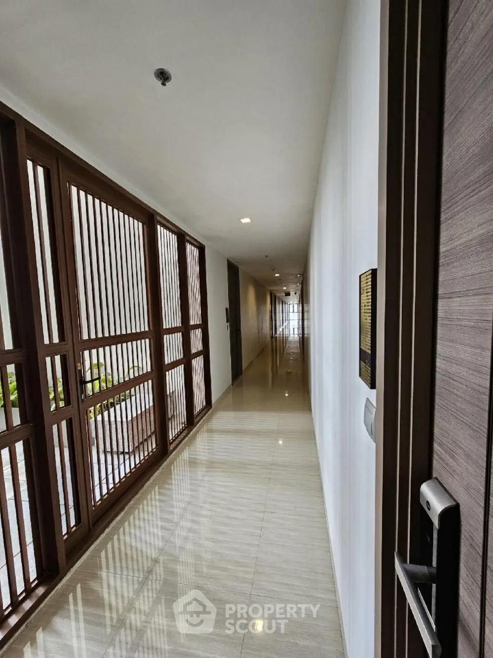 Modern apartment hallway with sleek wooden accents and polished flooring