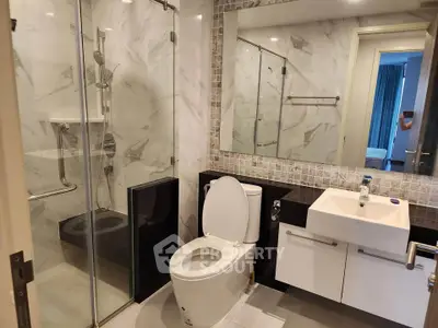 Modern bathroom with glass shower, sleek sink, and elegant tile design.