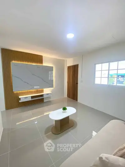 Modern living room with sleek design, featuring a stylish wall panel and elegant coffee table.