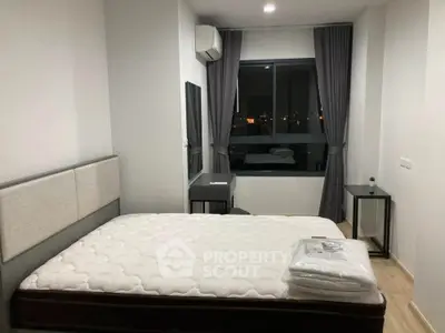 Modern bedroom with large window and city view, featuring minimalist decor and air conditioning.