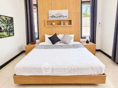 Spacious modern bedroom with elegant decor and large windows for natural light.