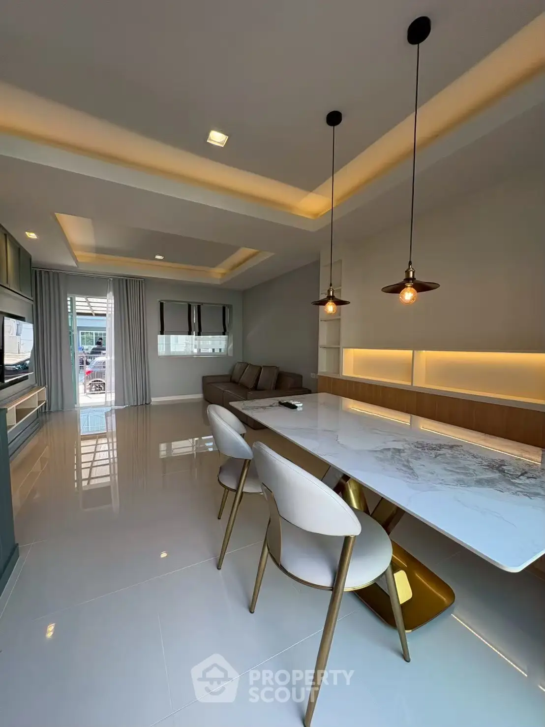Modern open-plan living room with elegant dining area and stylish lighting