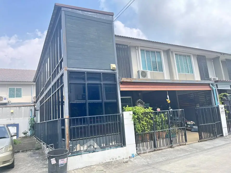 Modern townhouse with spacious carport and sleek exterior design in a suburban neighborhood.