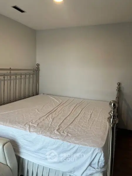 Spacious bedroom with elegant metal bed frame and crisp white bedding, perfect for relaxation.