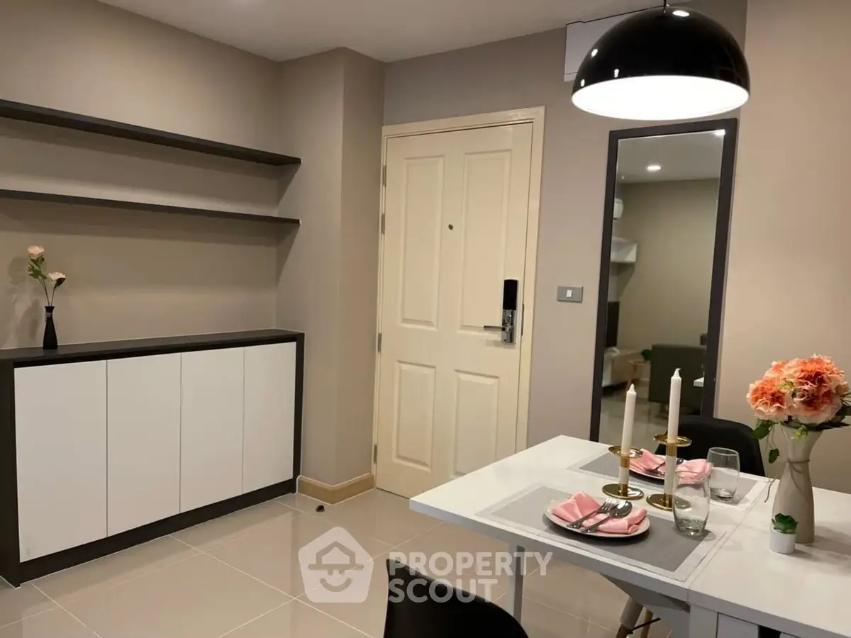 Modern dining area with elegant decor and sleek shelving in a stylish apartment.