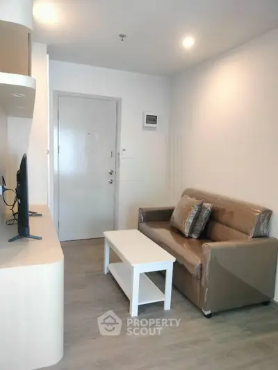 Cozy living room with modern sofa and TV setup, perfect for relaxation.