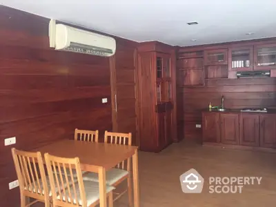 Spacious wooden kitchen with dining area and air conditioning unit