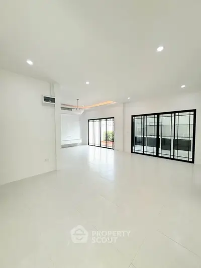 Spacious modern living room with large windows and bright lighting