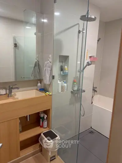 Modern bathroom with glass shower and sleek wooden vanity