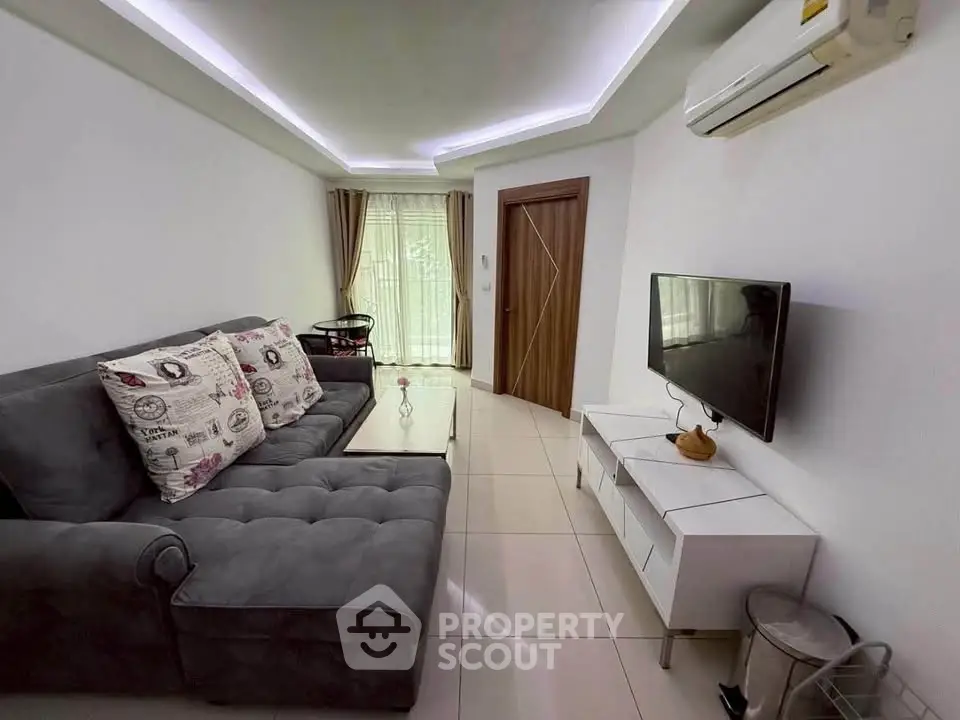 Modern living room with stylish sofa, wall-mounted TV, and air conditioning in a cozy apartment.