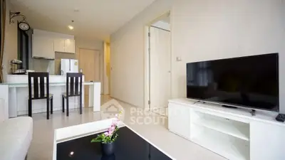 Modern living room with open kitchen and sleek furniture in a cozy apartment.