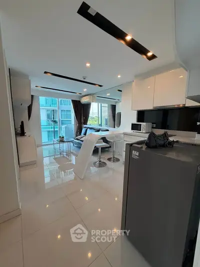 Modern open-layout kitchen and living area with sleek design and natural light.