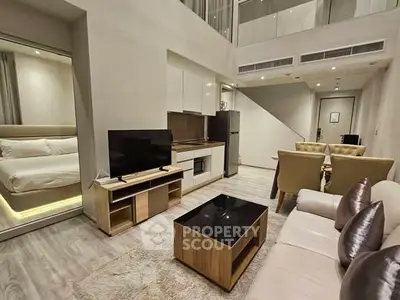 Modern duplex apartment with open living area, sleek kitchen, and cozy bedroom.