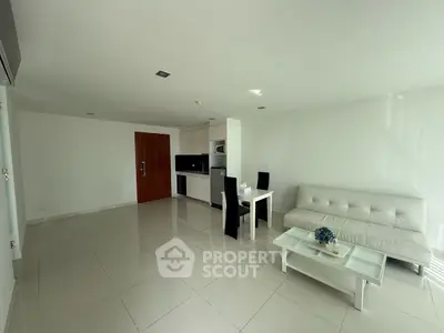 Spacious modern living room with sleek white furniture and open kitchen layout