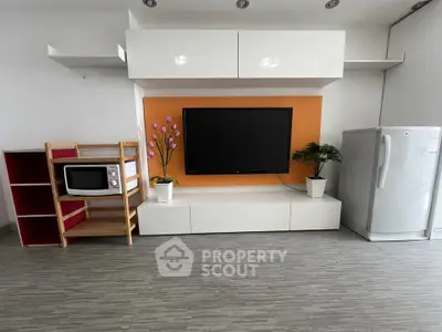 Modern living room with sleek TV setup, stylish shelving, and contemporary appliances.