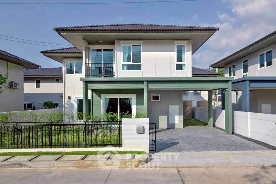 Modern two-story house with driveway and lush garden in a serene neighborhood.