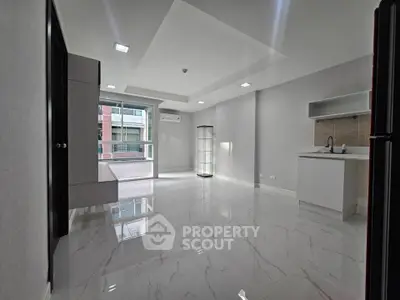 Modern open-layout living space with sleek flooring and ample natural light
