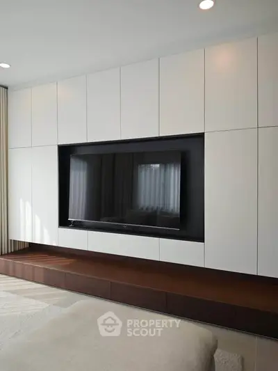 Modern living room with sleek built-in entertainment center and large TV