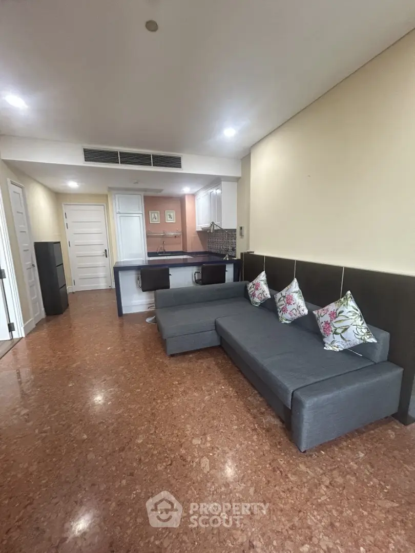Spacious living room with modern sofa and open kitchen layout