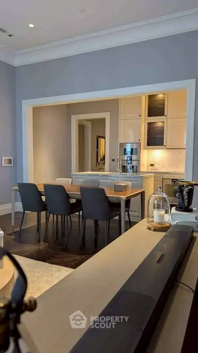 Elegant open-layout kitchen and dining area with modern furnishings and sleek design.