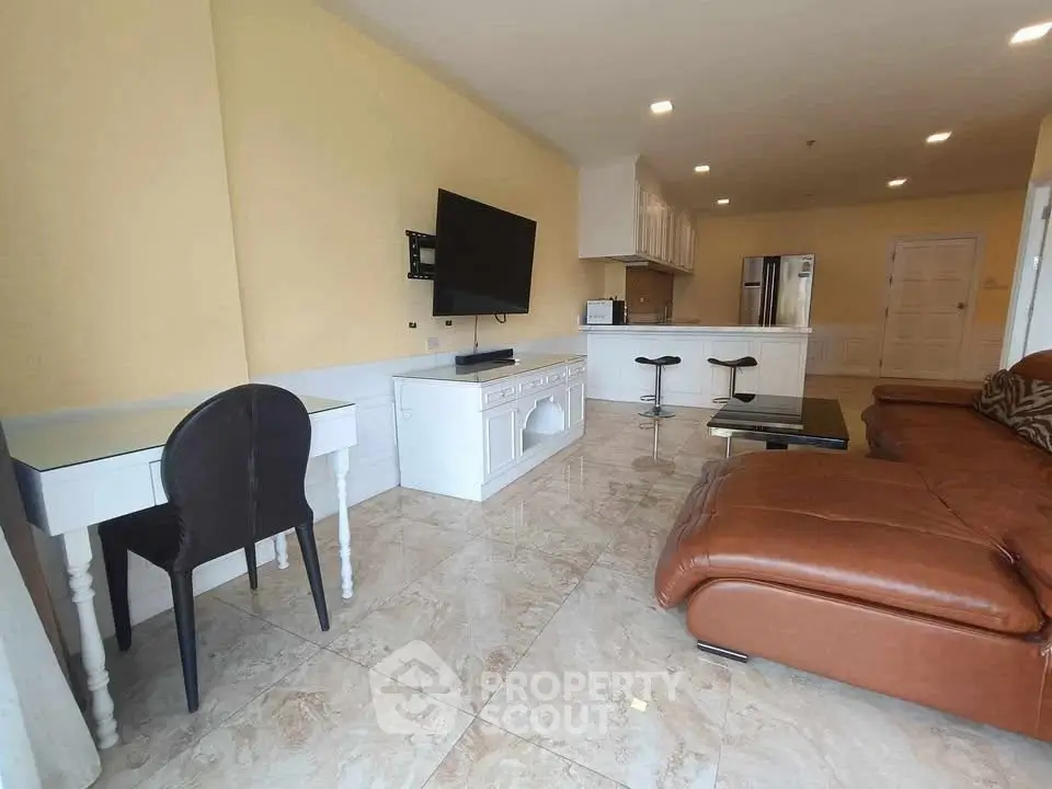 Spacious living room with modern furnishings and open kitchen layout