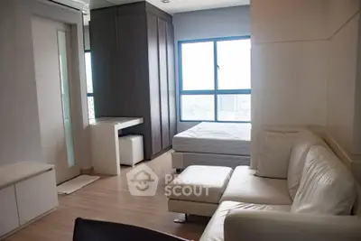 Modern studio apartment with sleek furniture and large window view