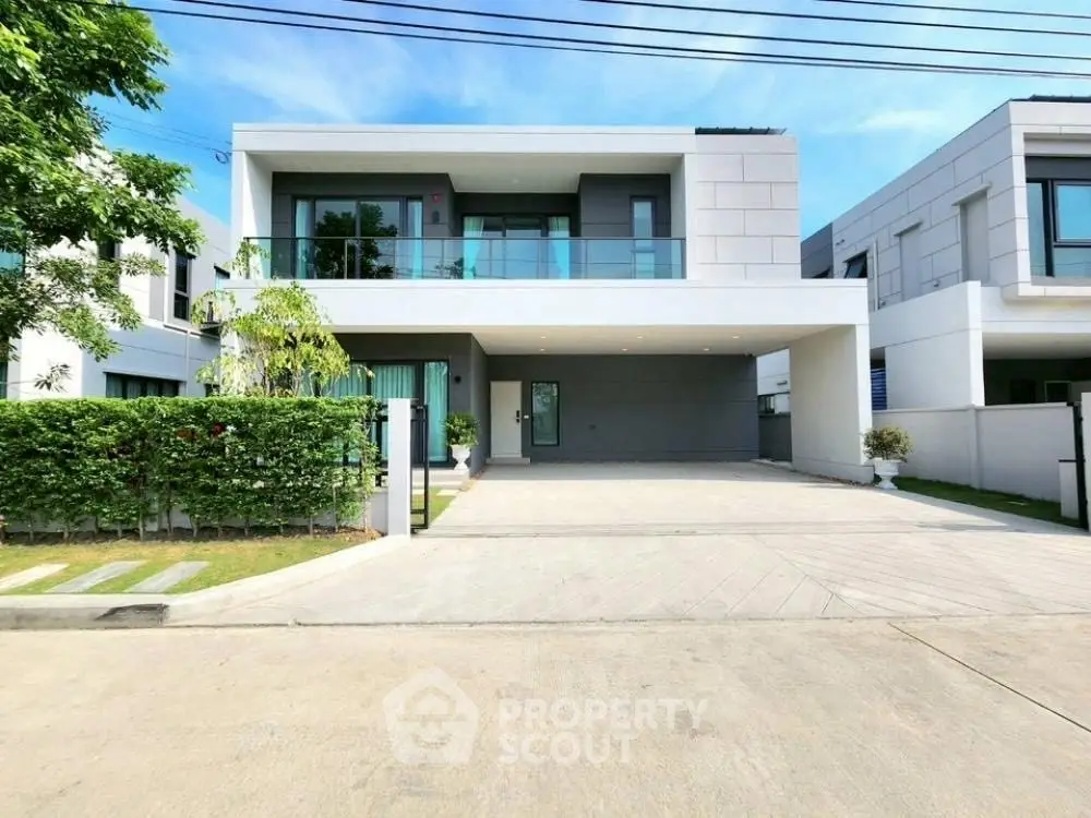 Modern two-story house with spacious driveway and lush greenery