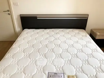 Spacious bedroom with modern bed and stylish headboard in a cozy apartment.