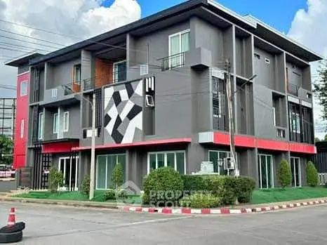 Modern multi-story building with geometric facade and lush landscaping