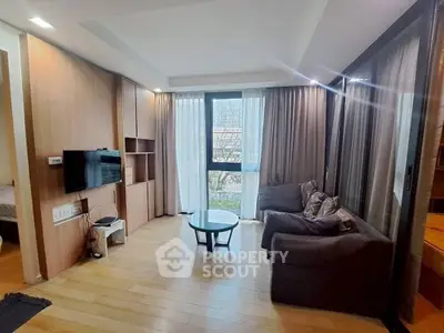 Modern living room with large window and cozy seating area in a stylish apartment.