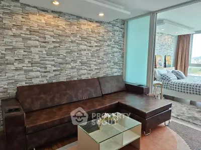 Modern living room with stylish stone accent wall and cozy brown leather sofa