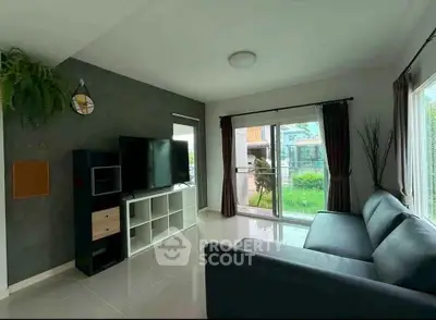 Modern living room with large windows and garden view, featuring sleek furniture and minimalist decor.