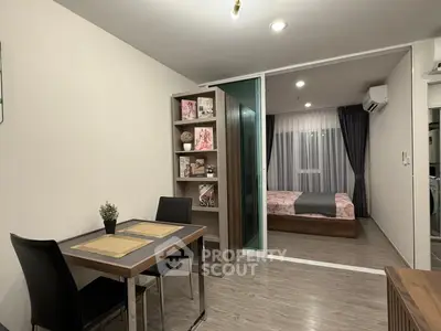 Modern apartment interior with dining area and bedroom, featuring sleek furniture and stylish decor.
