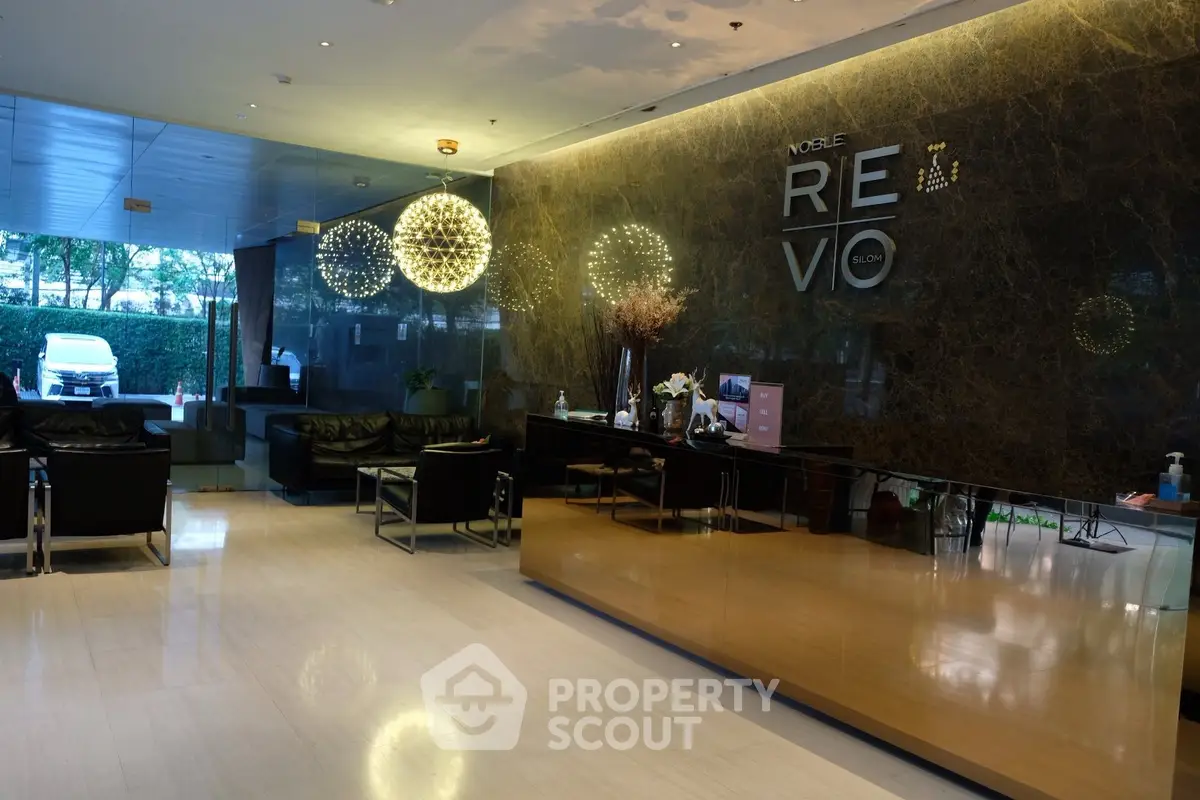 Luxurious modern lobby with elegant seating and decorative lighting in upscale building.