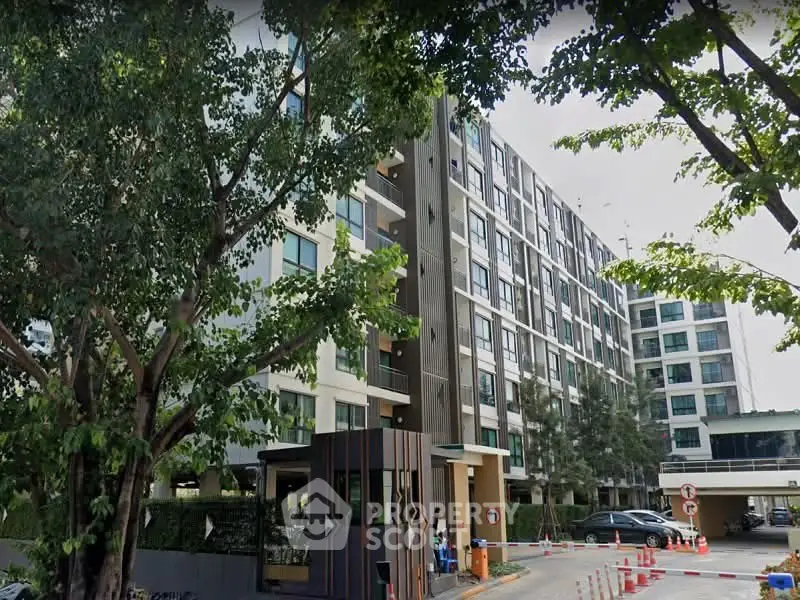 Modern multi-story residential building with lush greenery and secure entrance.