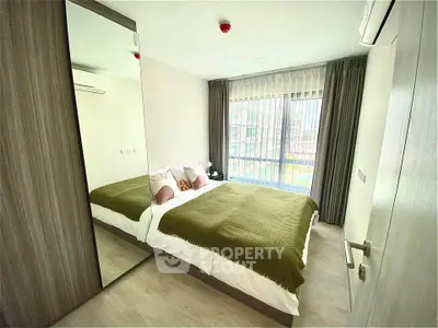 Modern bedroom with large window and stylish decor in a contemporary apartment.