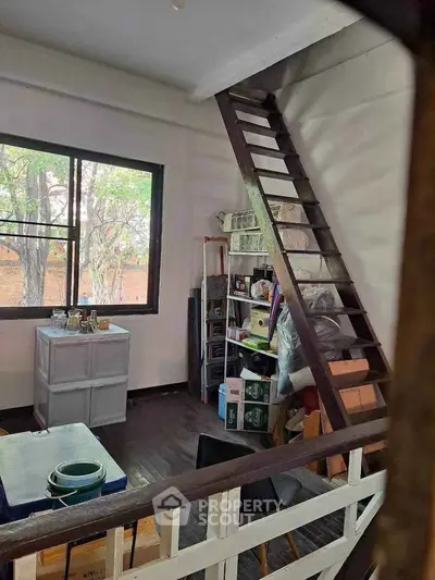 Cozy loft-style room with ladder access and large window view