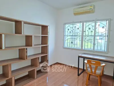 Bright study room with wooden shelves and desk, featuring air conditioning and natural light.