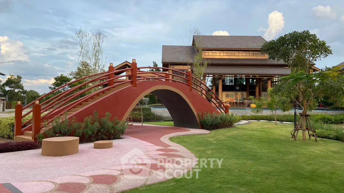 Charming garden with a picturesque bridge and traditional house, perfect for serene living.