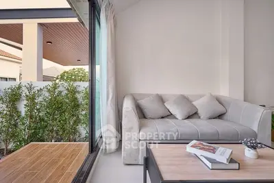 Modern living room with cozy sofa and garden view, perfect for relaxation.