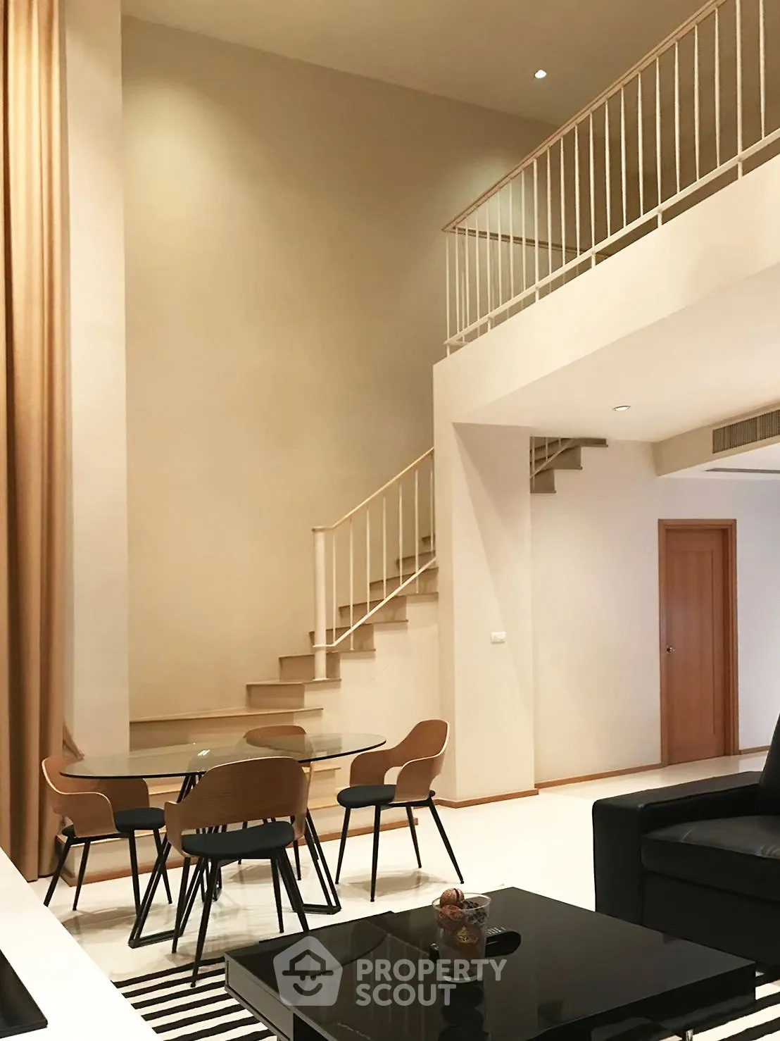 Spacious modern living room with high ceilings and elegant staircase