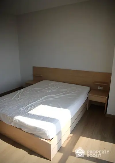 Minimalist bedroom with wooden flooring and natural light