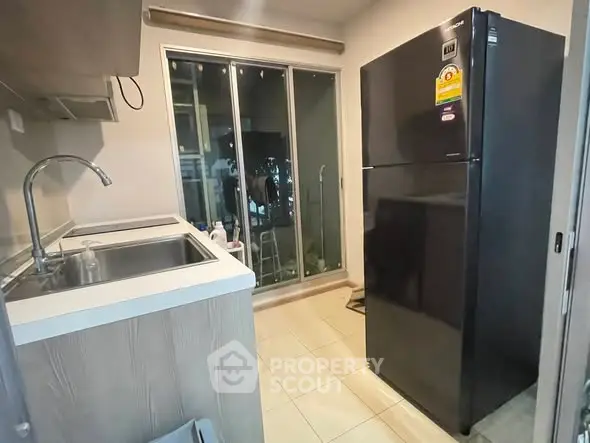 Modern kitchen with sleek black fridge and sliding glass doors