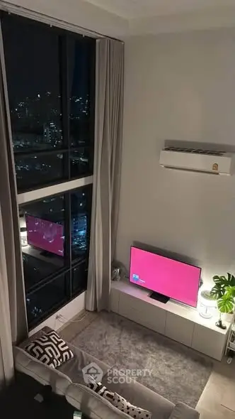 Modern living room with large windows and city view, featuring stylish decor and cozy ambiance.