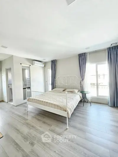 Spacious bedroom with large windows and elegant decor