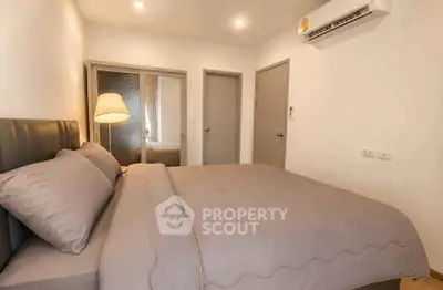 Cozy bedroom with modern decor and soft lighting, featuring a comfortable bed and mirrored closet doors.