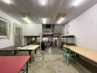 Spacious industrial-style room with concrete floors and high ceilings, ideal for creative workspace or storage.